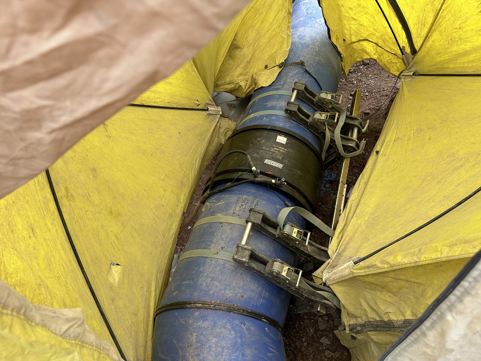 Butt fusion clamps on large diameter HDPE water main in welding tent